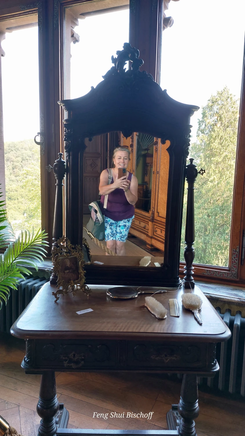 Die Feng Shui Bischoff spiegelt sich in einem Kosmetikspiegel in einem alten Schloss, gibt sich damit einen schönen Rahmen